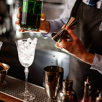 Bartender,In,Black,Apron,Begins,To,Prepare,Green,Alcoholic,Cocktail.